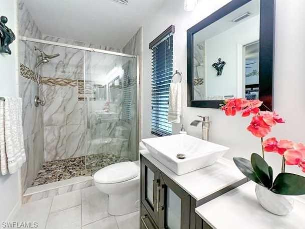 3790 35th Avenue Northeast Naples, FL 34120 - Photo 25 of 27 a bathroom with a sink a toilet and shower