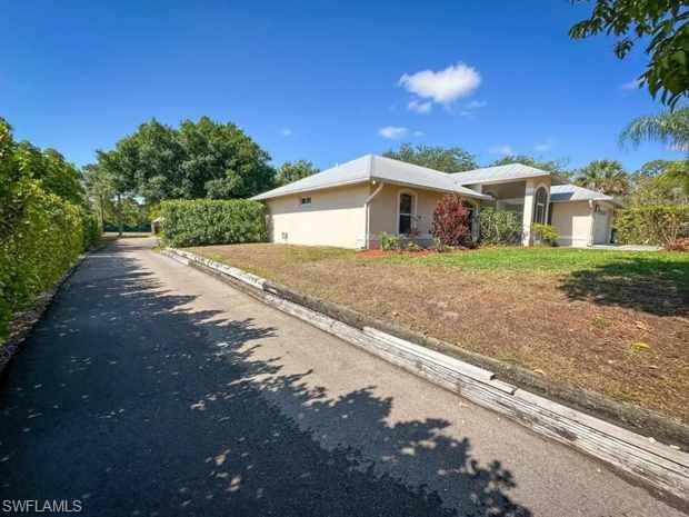 3790 35th Avenue Northeast Naples, FL 34120 - Photo 10 of 27 a front view of a house with a yard