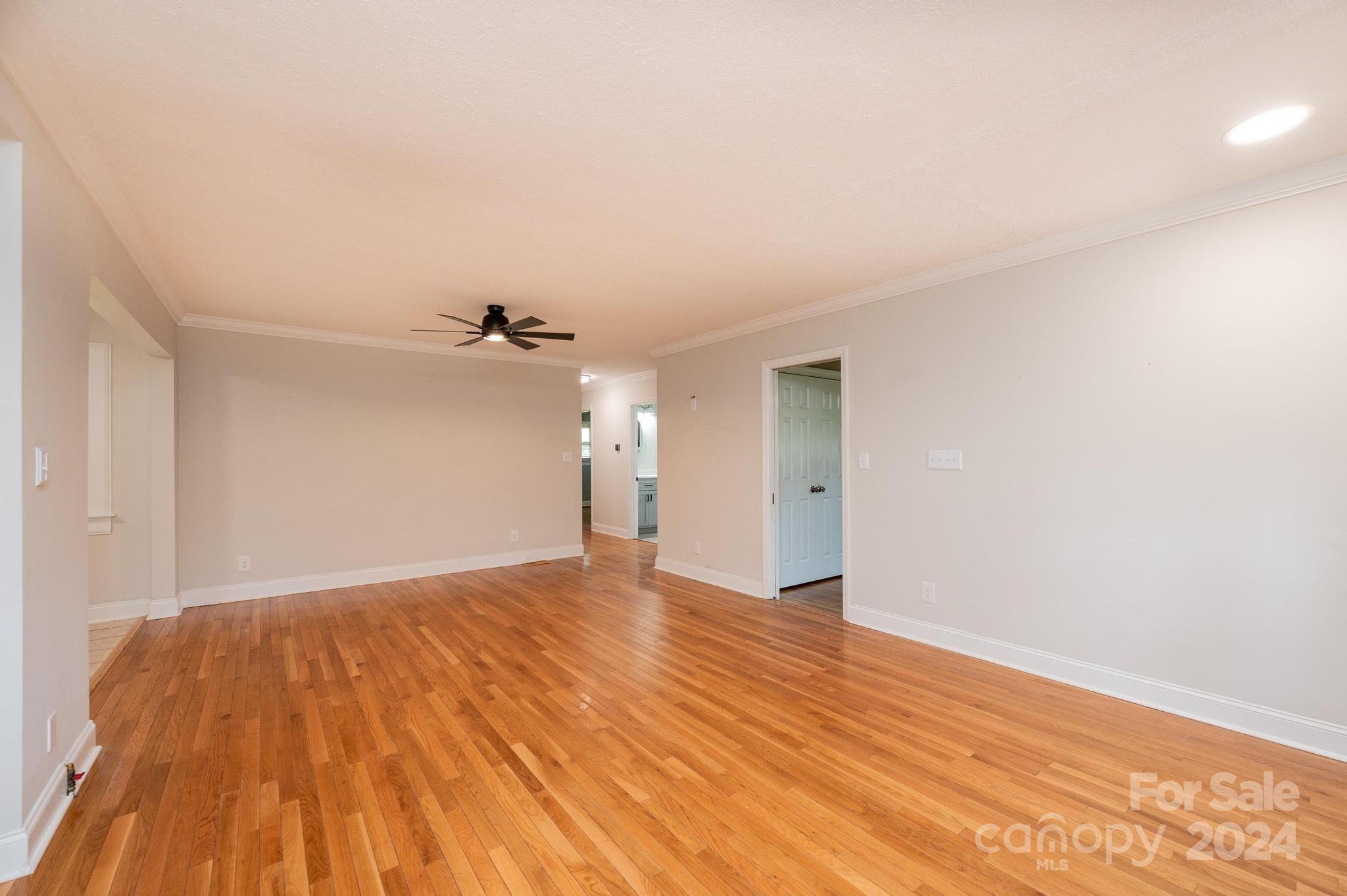 1691 Cat Square Road Vale, NC 28168 - Photo 14 of 43 an empty room with wooden floor ceiling fan and windows