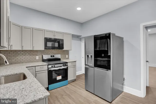 a kitchen with granite countertop a stove and a refrigerator