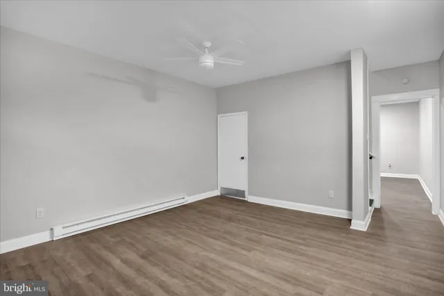 a view of an empty room with wooden floor