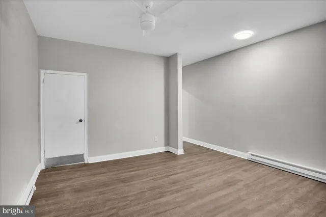 a view of an empty room with wooden floor