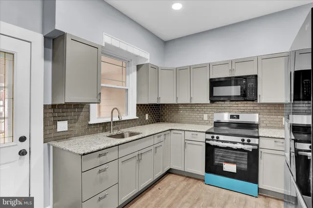 a kitchen with granite countertop a sink stainless steel appliances and cabinets