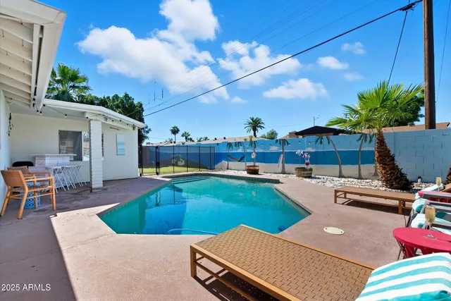 a view of a backyard with swimming pool and furniture