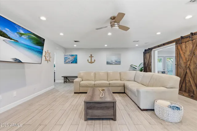 a living room with furniture and a ceiling fan