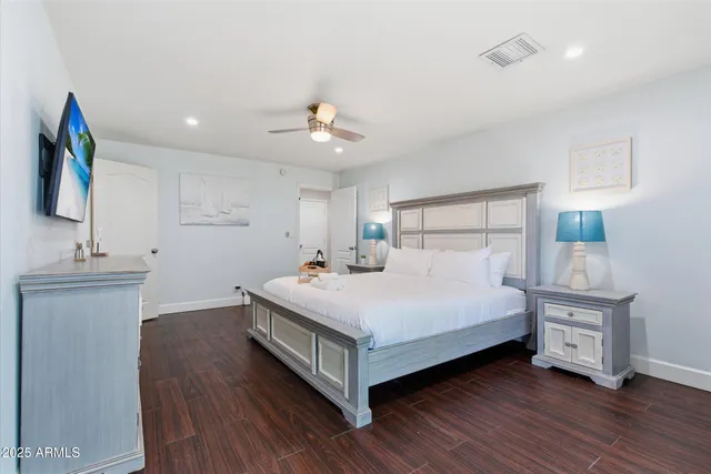 a bedroom with a bed and a flat tv screen on the dresser