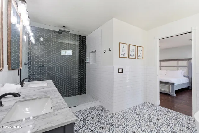 a bathroom with a double vanity sink mirror and shower