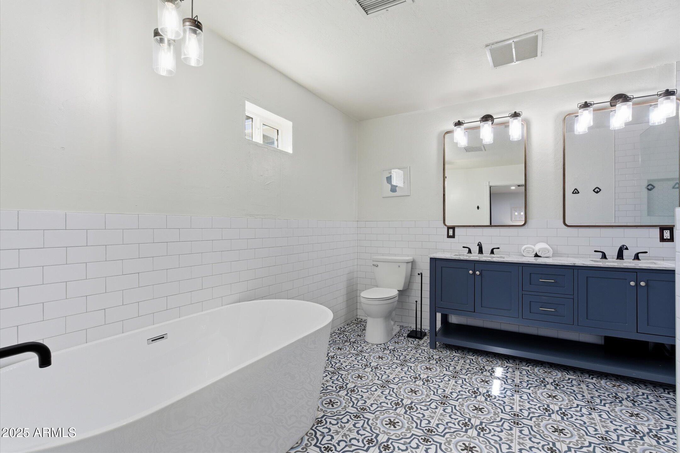 2530 North 68th Place Scottsdale, AZ 85257 - Photo 23 of 52 a bathroom with a bathtub sink mirror vanity and toilet