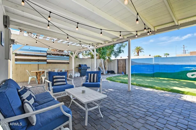 a view of a patio with table and chairs with wooden floor and fence