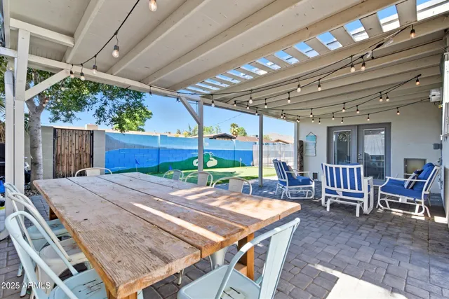 a view of a backyard with table and chairs and a barbeque