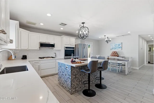 a kitchen with stainless steel appliances kitchen island granite countertop a sink and cabinets