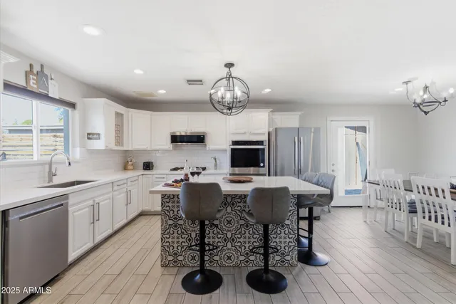 a view of a dining room with furniture a chandelier and wooden floor