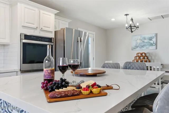 a kitchen with stainless steel appliances a table chairs refrigerator and cabinets