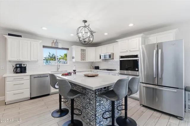 a open kitchen with stainless steel appliances granite countertop a dishwasher a dining table and chairs with wooden floor