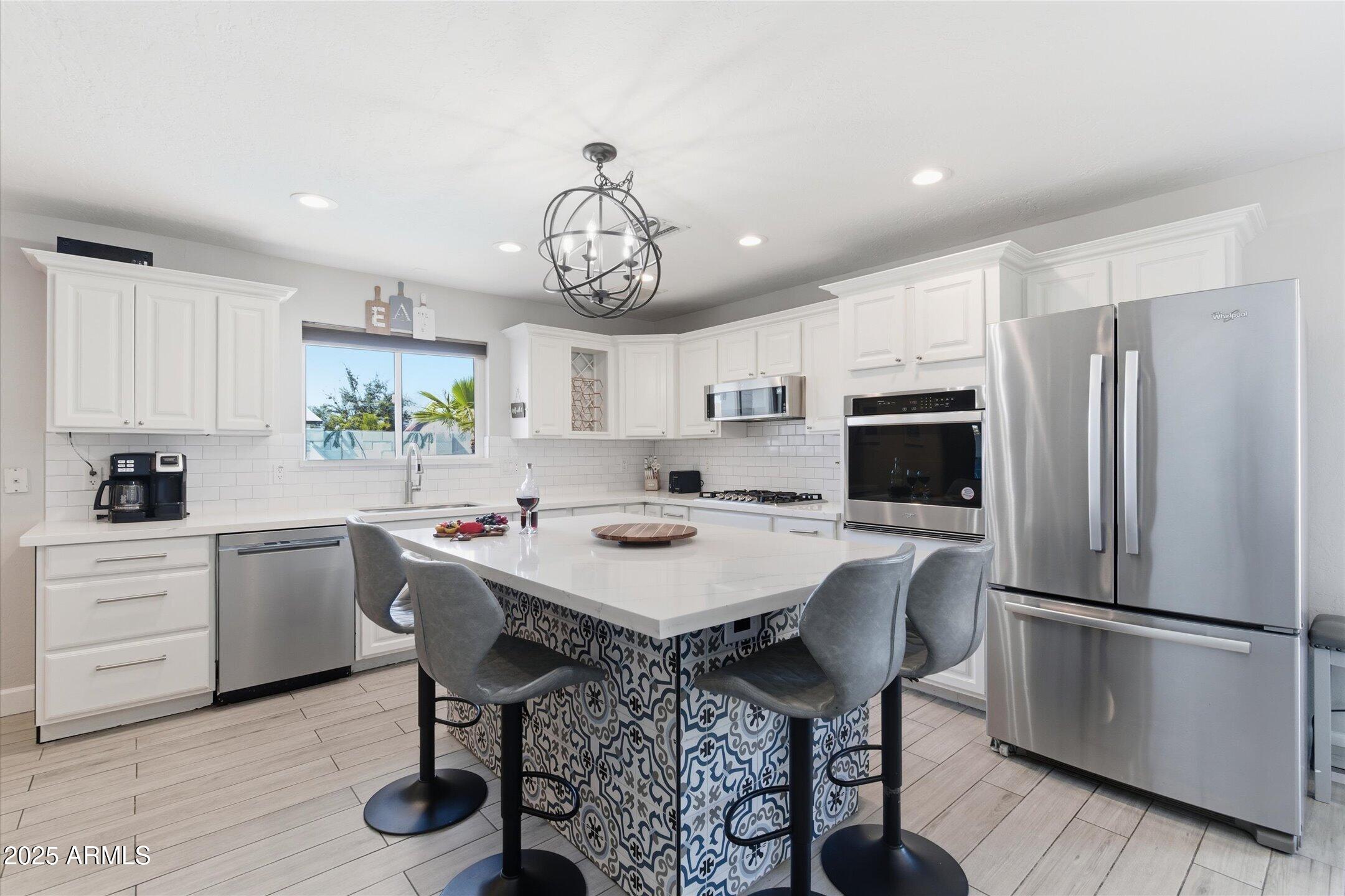 2530 North 68th Place Scottsdale, AZ 85257 - Photo 8 of 52 a kitchen with stainless steel appliances a table chairs refrigerator and cabinets
