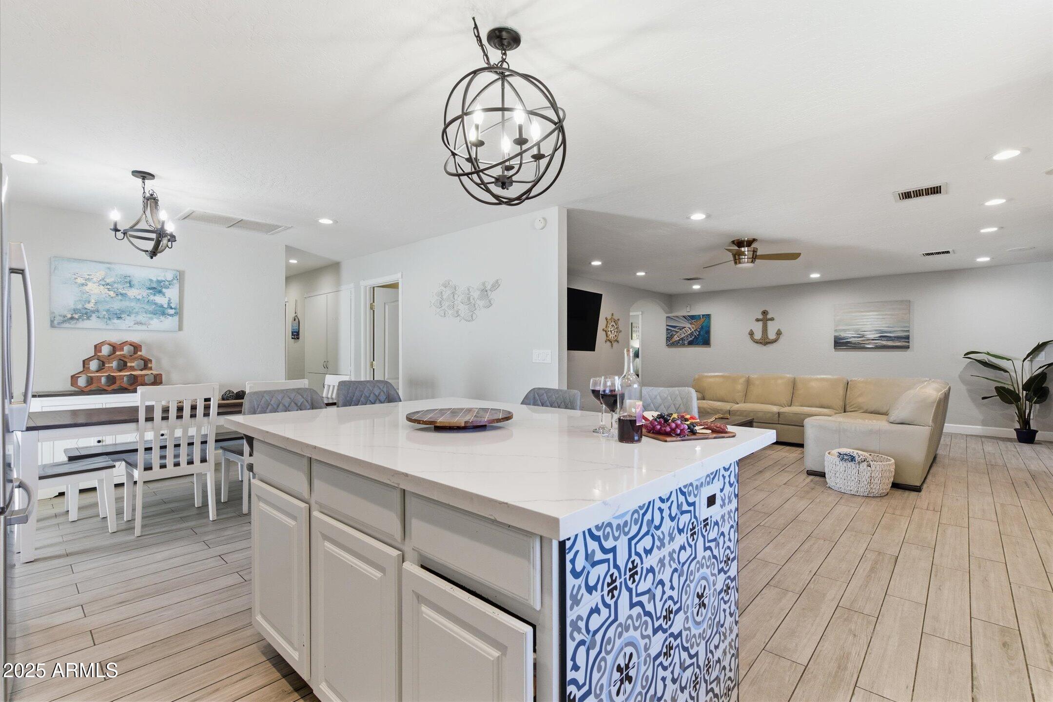 2530 North 68th Place Scottsdale, AZ 85257 - Photo 9 of 52 a open kitchen with stainless steel appliances granite countertop a dishwasher a dining table and chairs with wooden floor