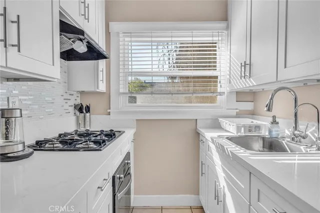 a kitchen with stainless steel appliances granite countertop a sink and a stove