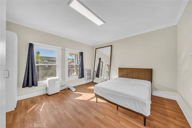 a bedroom with a bed and wooden floor