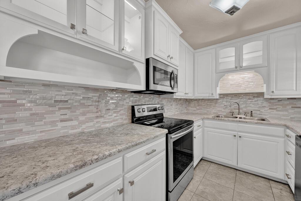 1606 Tularosa Street Amarillo, TX 79102 - Photo 13 of 22 a kitchen with granite countertop white cabinets stainless steel appliances and a sink