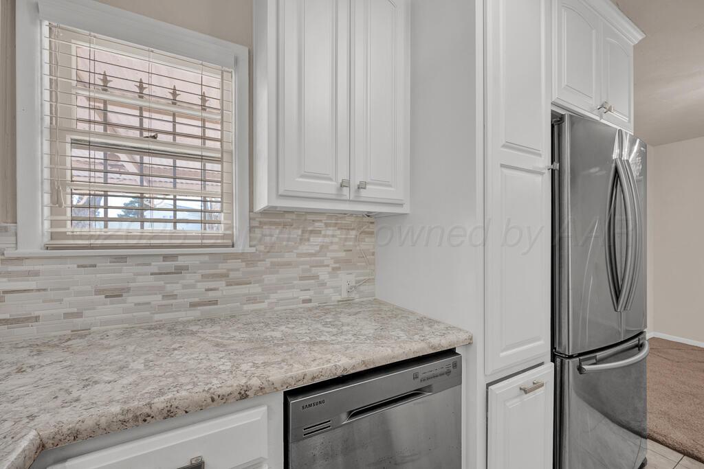1606 Tularosa Street Amarillo, TX 79102 - Photo 14 of 22 a kitchen with granite countertop a refrigerator and a sink