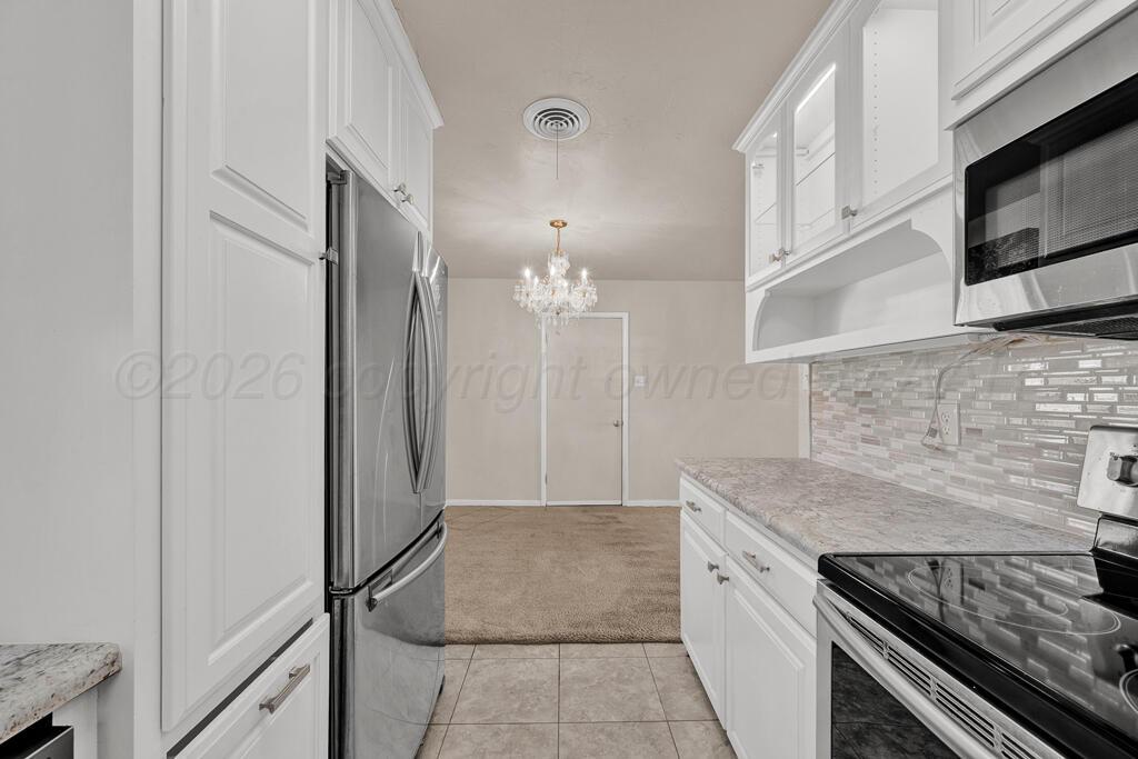 1606 Tularosa Street Amarillo, TX 79102 - Photo 15 of 22 a kitchen with granite countertop a sink stove and refrigerator