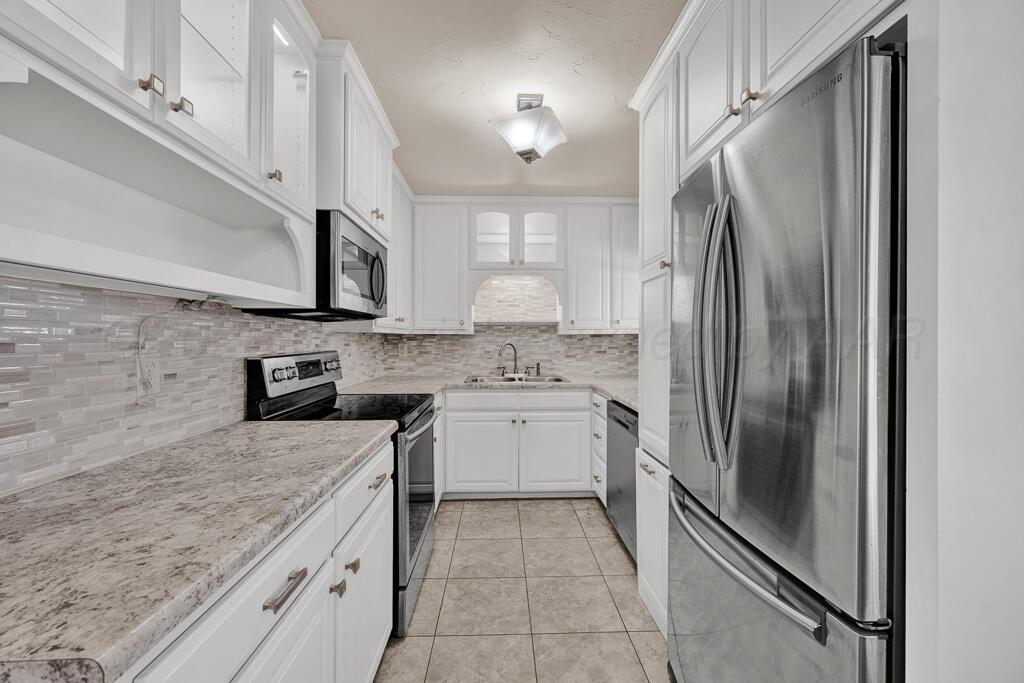1606 Tularosa Street Amarillo, TX 79102 - Photo 3 of 22 a kitchen with a refrigerator sink and cabinets