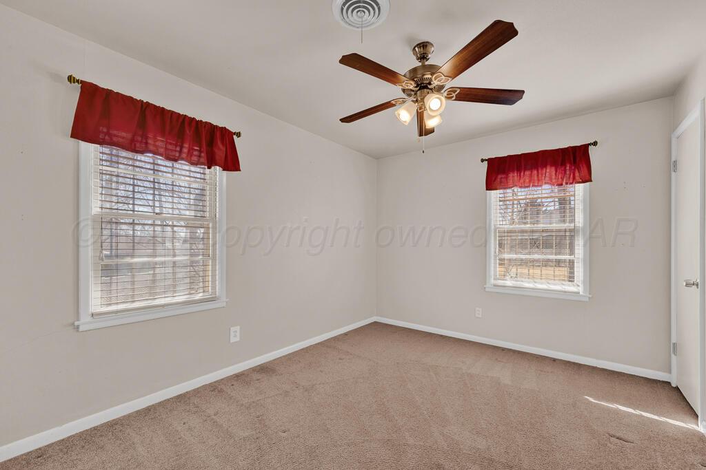 1606 Tularosa Street Amarillo, TX 79102 - Photo 7 of 22 a view of an empty room with chandelier fan and wooden floor