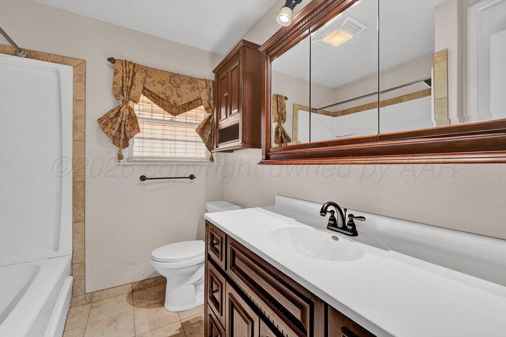 1606 Tularosa Street Amarillo, TX 79102 - Photo 8 of 22 a bathroom with a sink a toilet and a mirror