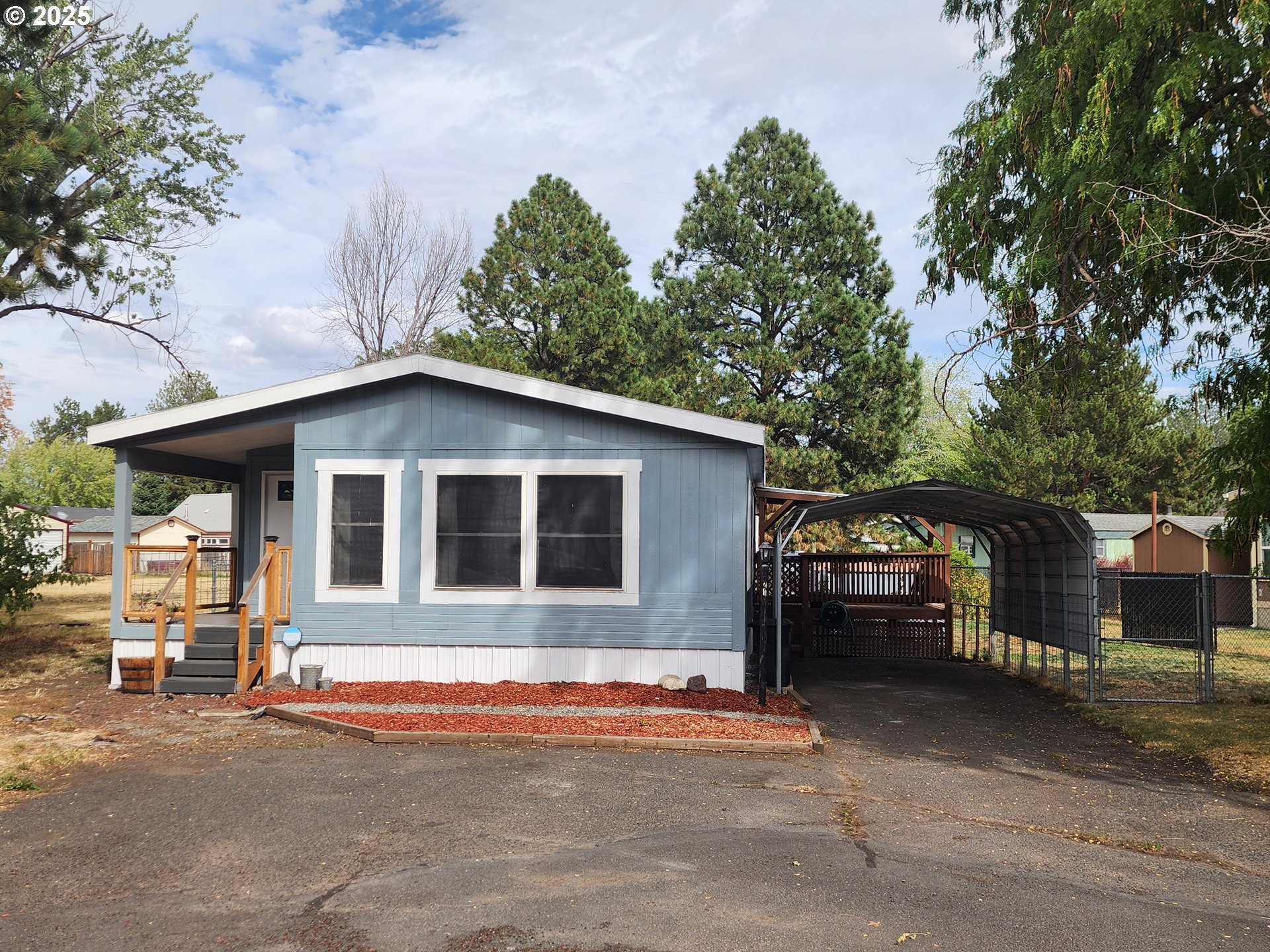1809 26th Street, Unit 21 La Grande, OR 97850 - Photo 1 of 18 a front view of a house with a yard and garage