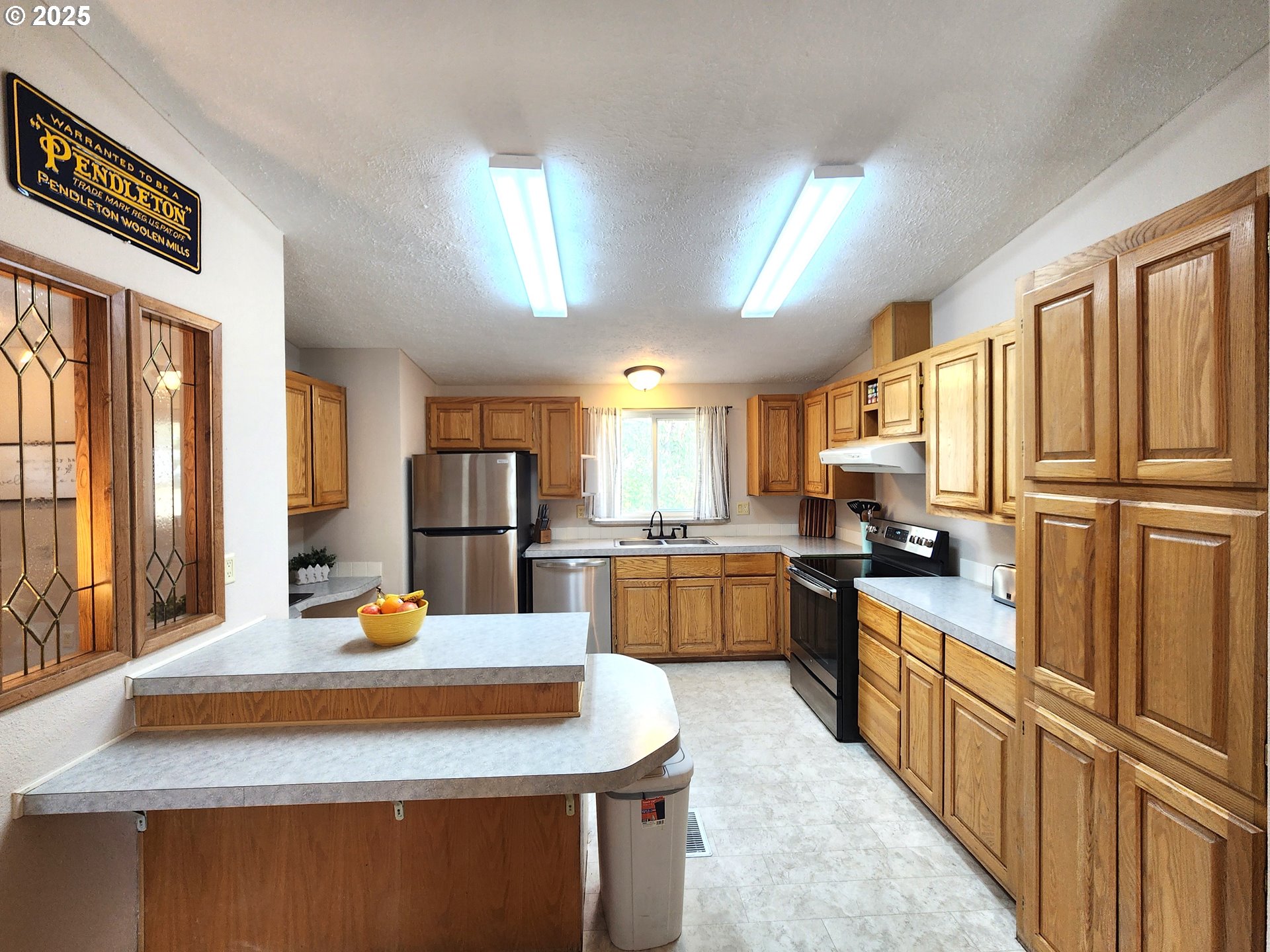 1809 26th Street, Unit 21 La Grande, OR 97850 - Photo 12 of 18 a kitchen with stainless steel appliances sink stove refrigerator and cabinets