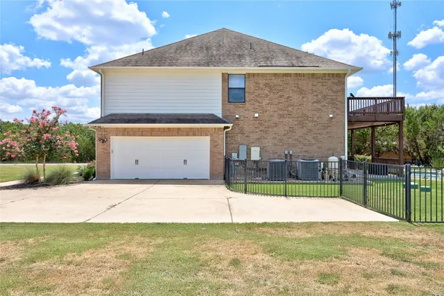 an aerial view of residential house with outdoor space and trees around