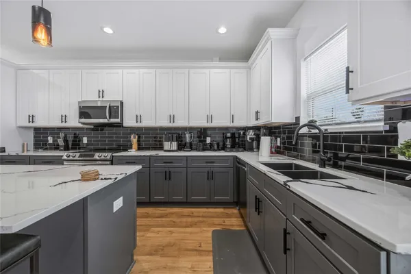 a kitchen with stainless steel appliances a stove sink microwave and cabinets