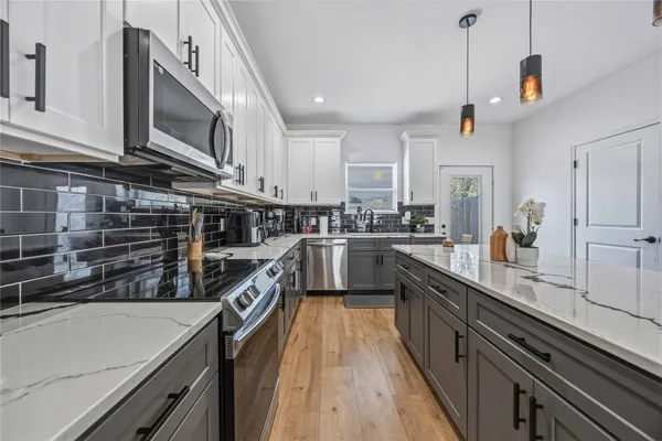 a kitchen with kitchen island granite countertop lots of counter top space stainless steel appliances and cabinets