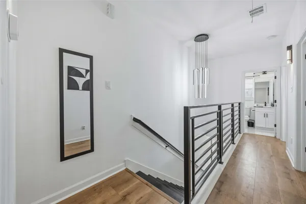 a view of a hallway with wooden floor and staircase