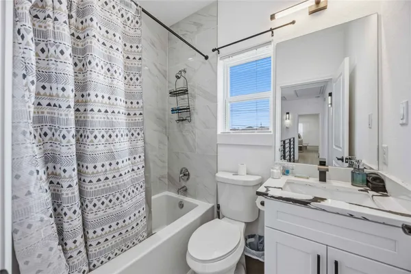 a bathroom with a double vanity sink toilet mirror and shower