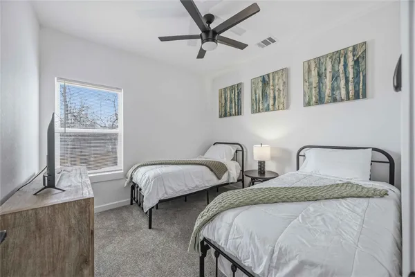 a bedroom with two beds and windows