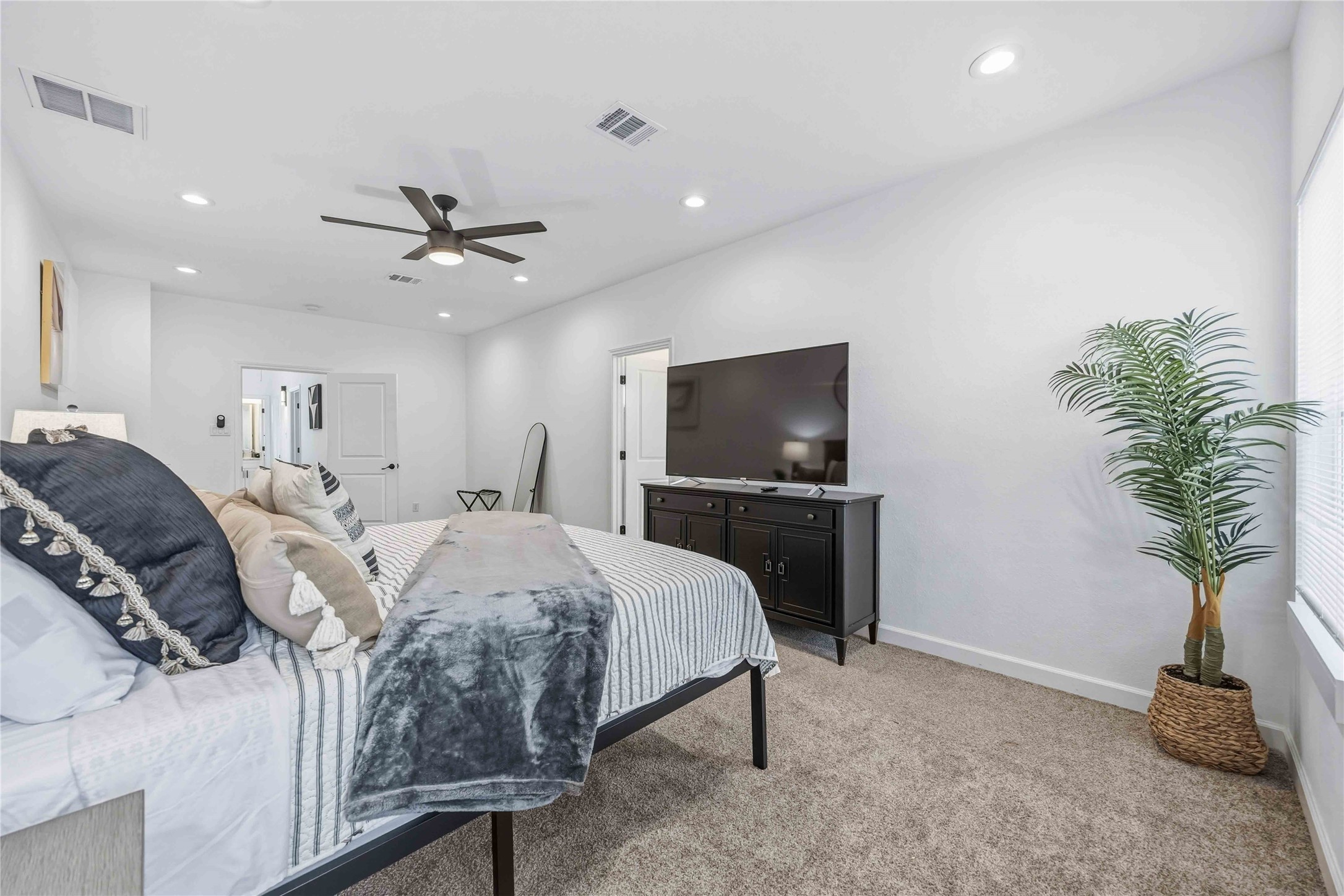 6130 Conley Street, Unit A Houston, TX 77021 - Photo 24 of 30 a spacious bedroom with a bed and a flat screen tv