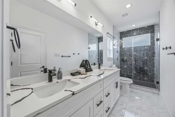 a bathroom with a double vanity sink toilet and shower