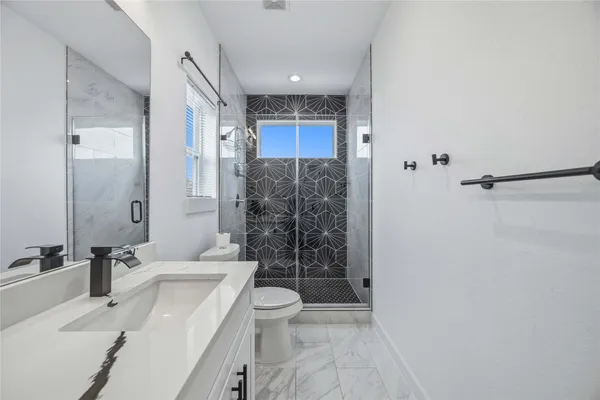 a bathroom with a sink a toilet and shower