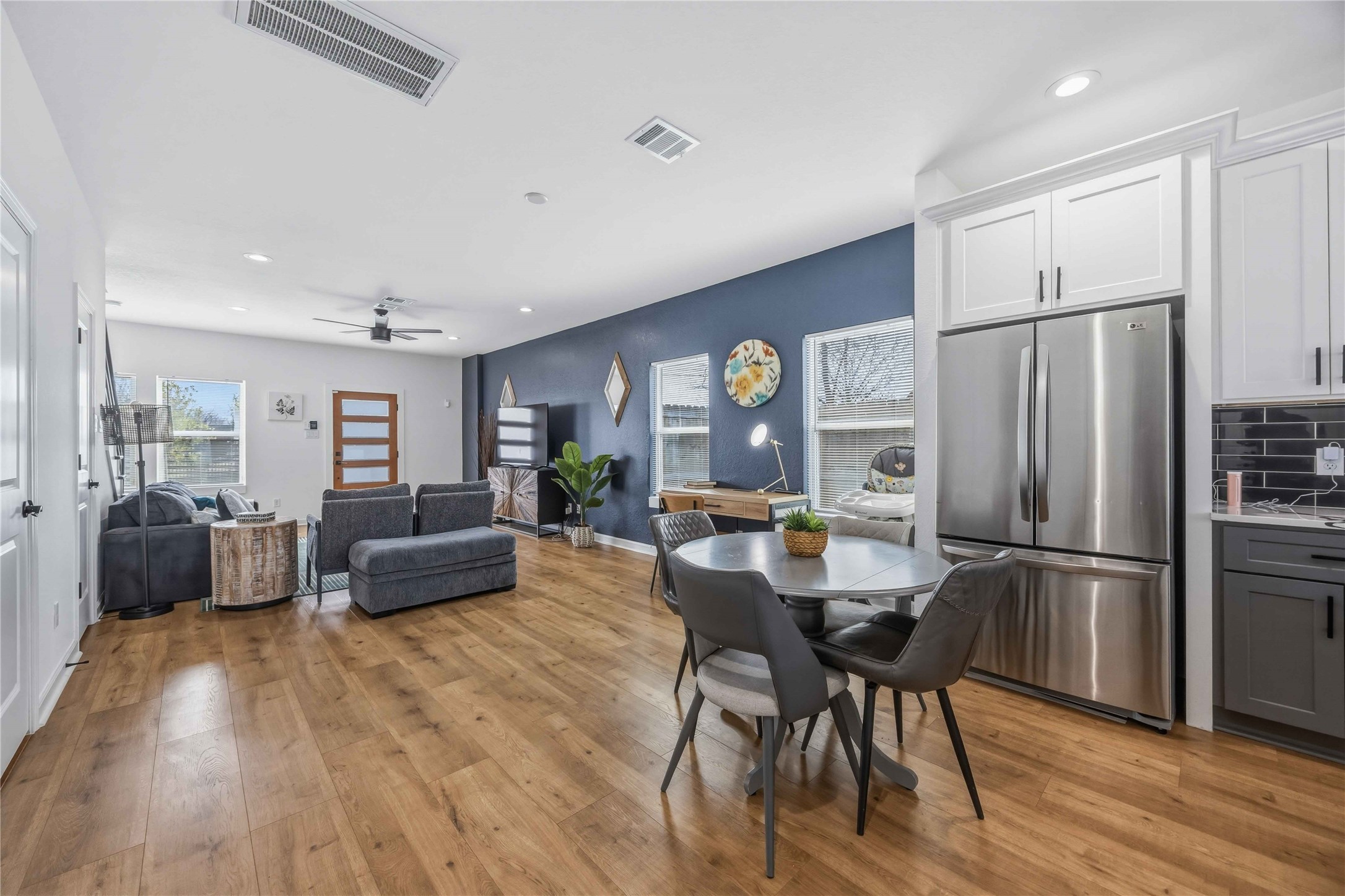 6130 Conley Street, Unit A Houston, TX 77021 - Photo 7 of 30 a kitchen with stainless steel appliances a refrigerator a stove a dining table and chairs with wooden floor