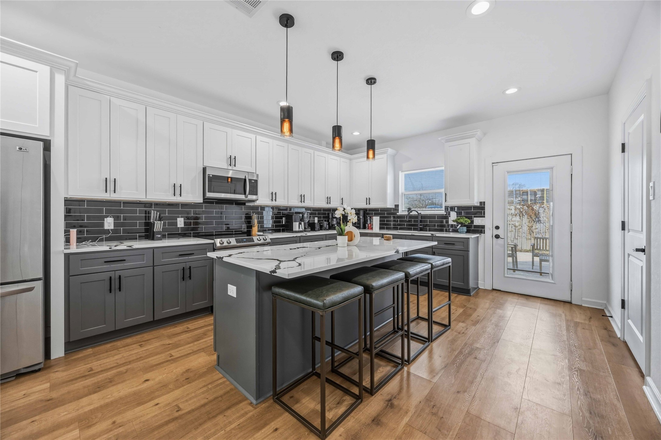 6130 Conley Street, Unit A Houston, TX 77021 - Photo 9 of 30 a kitchen with kitchen island granite countertop wooden floors and appliances