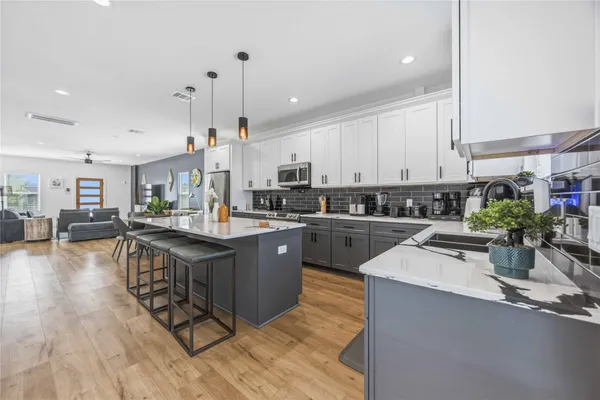 a kitchen with a sink a counter top space appliances and cabinets