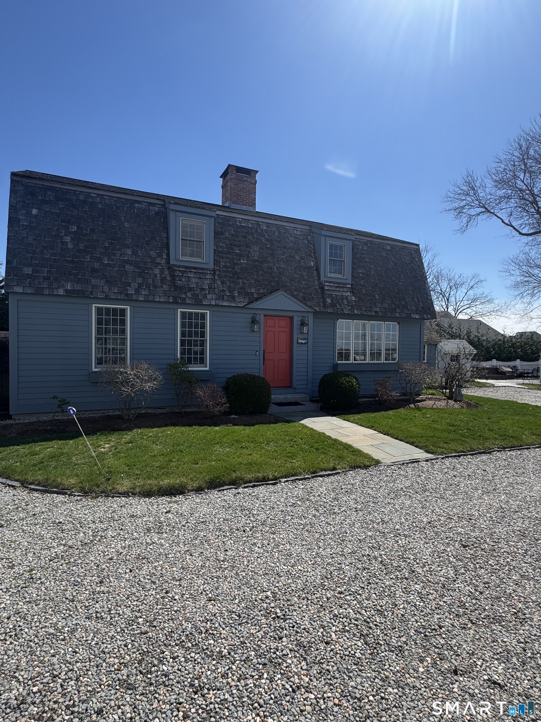 a brick house with a yard and a large tree
