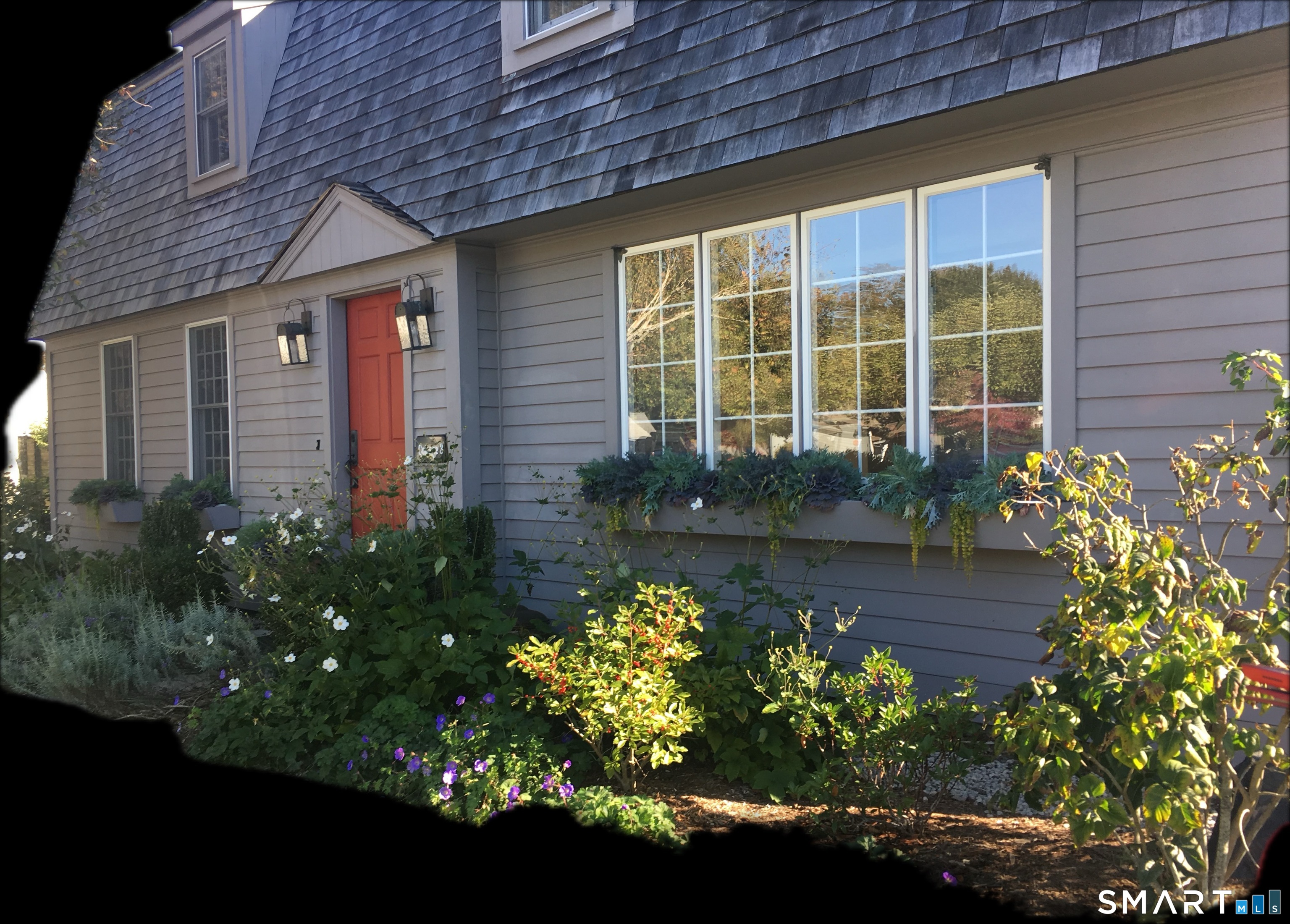 84 Waterside Lane, Unit 3 Clinton, CT 06413 - Photo 4 of 37 a front view of a house with a yard and flowers in it