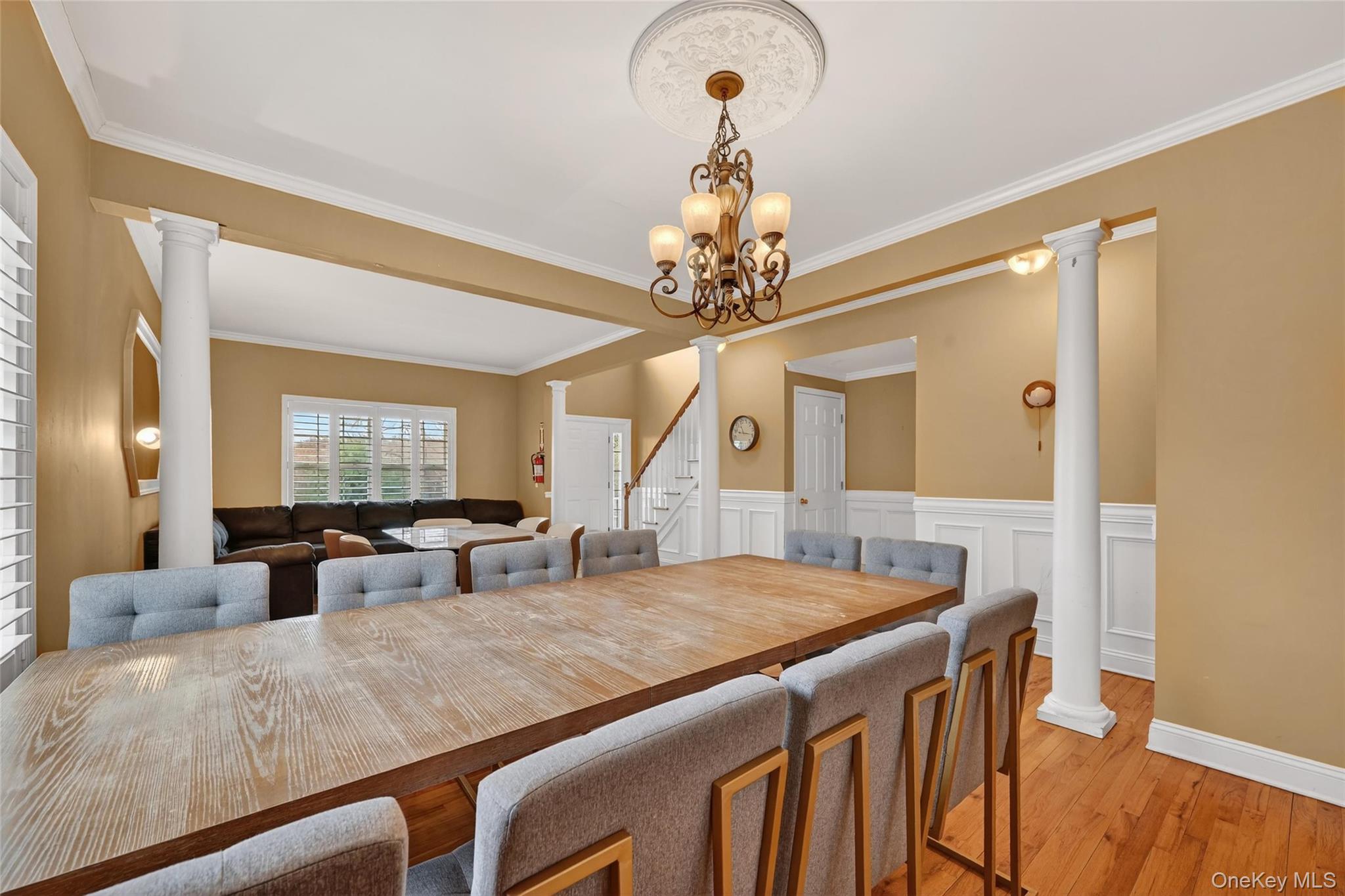 1071 Craigville Road Chester, NY 10918 - Photo 13 of 48 Dining room with ornate columns, a wainscoted wall, light wood-style flooring, a decorative wall, and ornamental molding