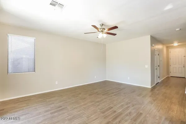 an empty room with wooden floor and window