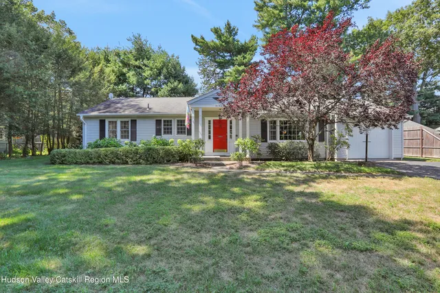a front view of house with yard and green space