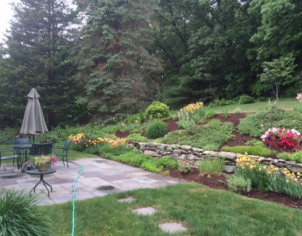 51 Harvard Road Stow, MA 01775 - Photo 15 of 17 a view of a chair and table in the garden