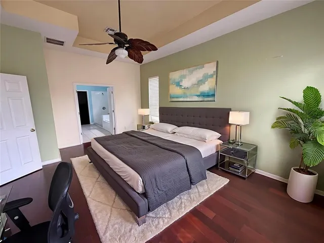 a view of a livingroom with wooden floor and a ceiling fan