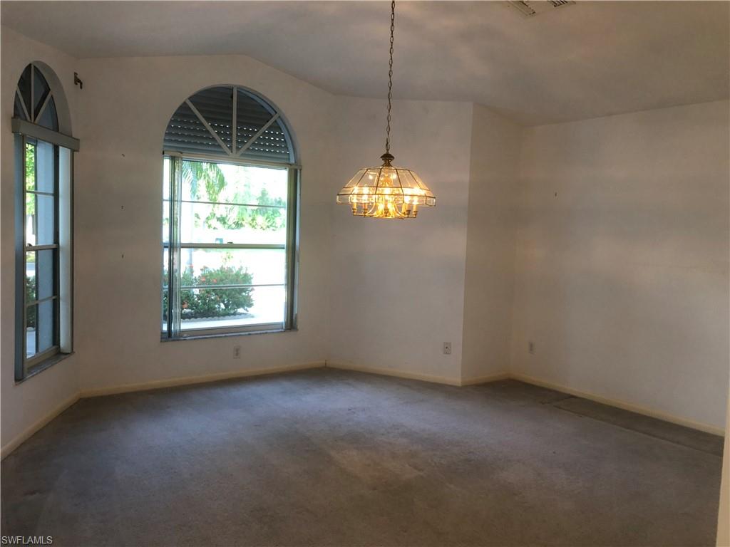 538 Roma Court Naples, FL 34110 - Photo 11 of 19 an empty room with windows and chandelier